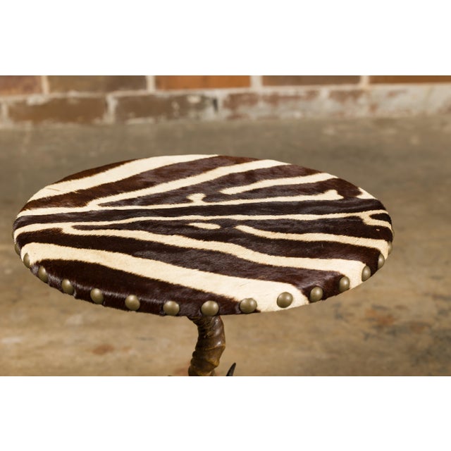 Two side tables with zebra skin circular tops and tripod horn bases. These two side tables are a striking fusion of...