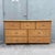 A warm and textural vintage dresser featuring a natural rattan frame with woven wicker drawer fronts and coordinating...