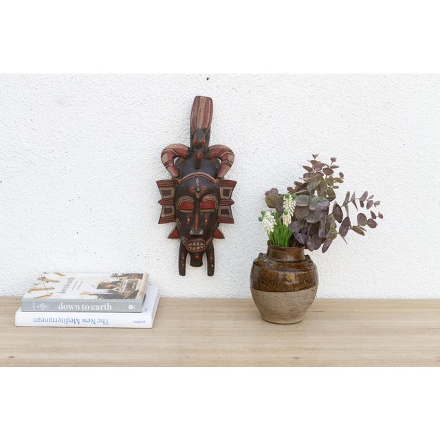 This striking mask, with its bold geometric patterns and avian-inspired design, speaks of a rich cultural heritage and...