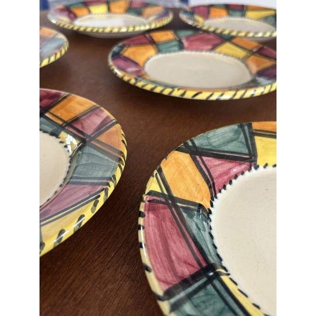 Superb set of 8 hand-painted ceramic dessert plates in a style attributed to Vallauris. Each plate features a colorful...