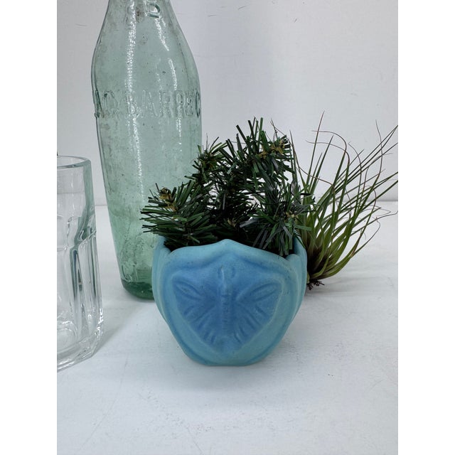 This small vase dates to the 1940's. Glazed in Van Briggle's turquoise Ming blue matte glaze. The moth/butterfly motif is...