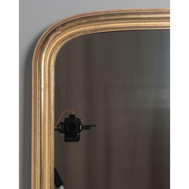 An early 20th century French Louis Philippe style mirror with elegant proportions and slightly curved top corners. Slim...