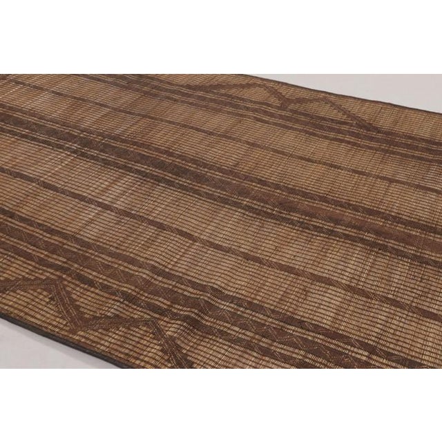 Made with handwoven reed and camel leather in Mauritania circa 1950-1960, this 7x9 vintage Tuareg mat is an exceptional...
