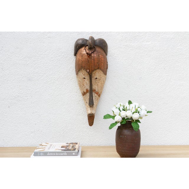 This expressive African tribal mask is a captivating piece with an elongated face, large eyes, and an open mouth,...
