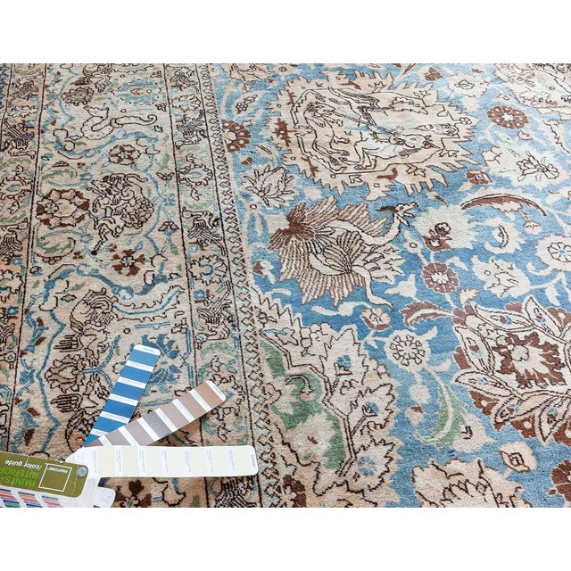 An unusual early 20th century Persian Antique Tabriz rug, the abrashed blue field with a cloud band, palmette and leafy...