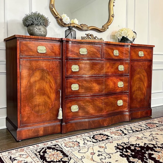 An Exceptional 1950s Henredon sideboard showcasing luminous crotch mahogany, a sculpted serpentine front, refined inlay,...