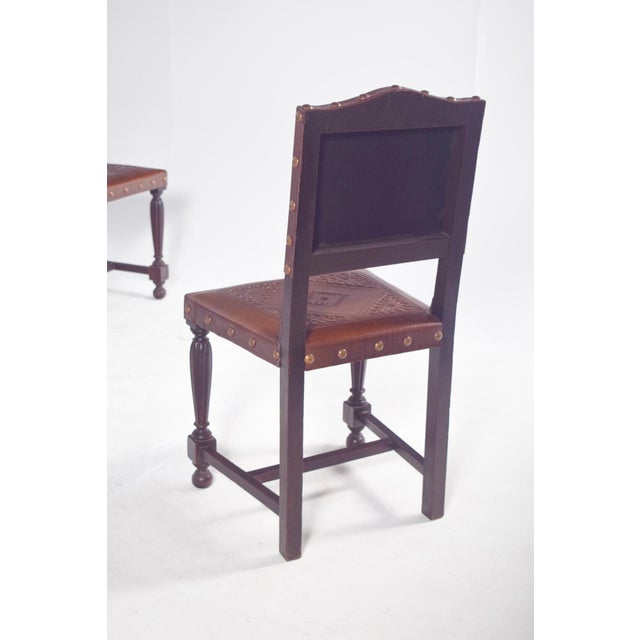 Set of eight chairs with backs and seats in studded leather. Two of the chairs have armrests, the structure is made of...