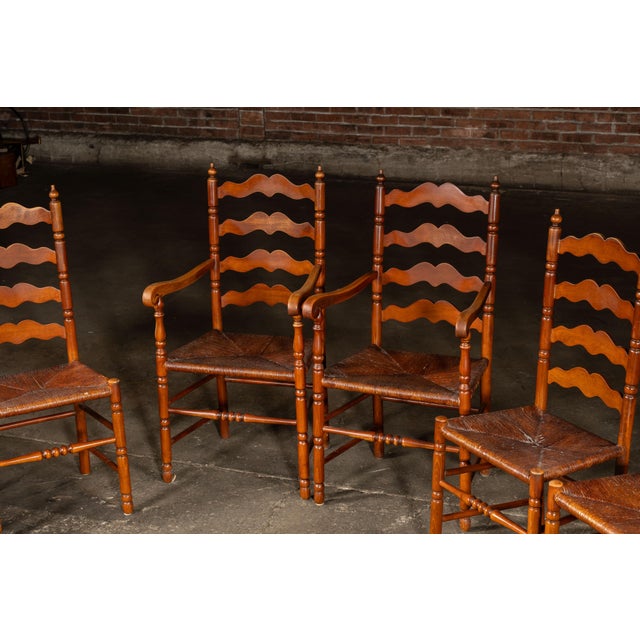 Set of eight turned wood ladder back chairs with rush-woven seats. This charming set of French Country-style dining chairs...