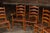 Set of eight turned wood ladder back chairs with rush-woven seats. This charming set of French Country-style dining chairs...