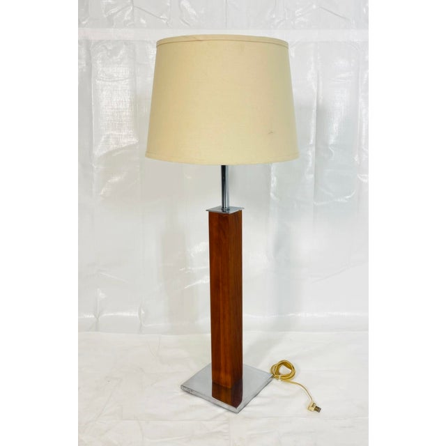 Elegant vintage table lamp designed by Walter Von Nessen, featuring a refined combination of warm walnut wood and polished...