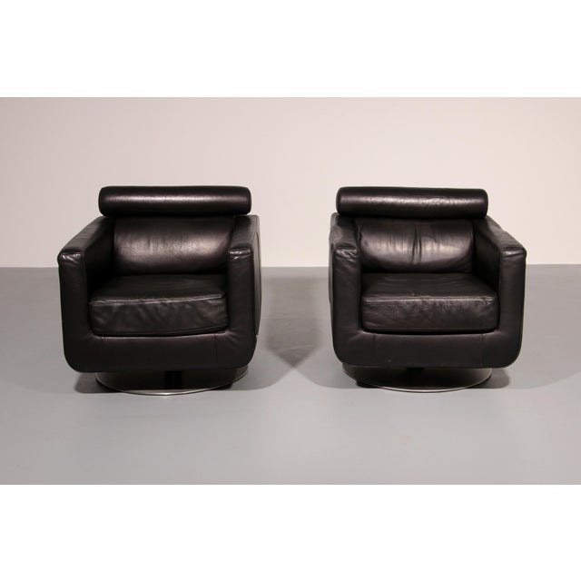 Bring timeless Italian design into your interior with this striking pair of modern black leather swivel lounge chairs by...