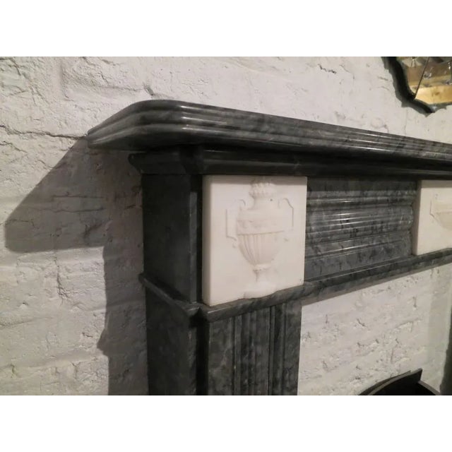 An antique Regency period fireplace in Bardiglio and statuary white marbles. The reeded and molded panels on the jambs...