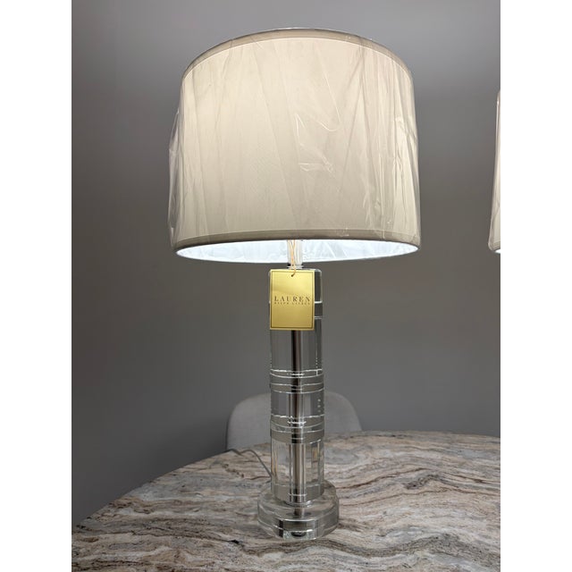 Sophisticated and elegant, this matching pair of Lauren Ralph Lauren crystal table lamps features faceted clear crystal...