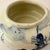 A charming vintage Delft blue pottery planter featuring a traditional Dutch windmill landscape hand-painted in cobalt blue...