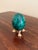 A beautifully proportioned malachite egg in richly veined shades of green and black resting on a neoclassical style brass...