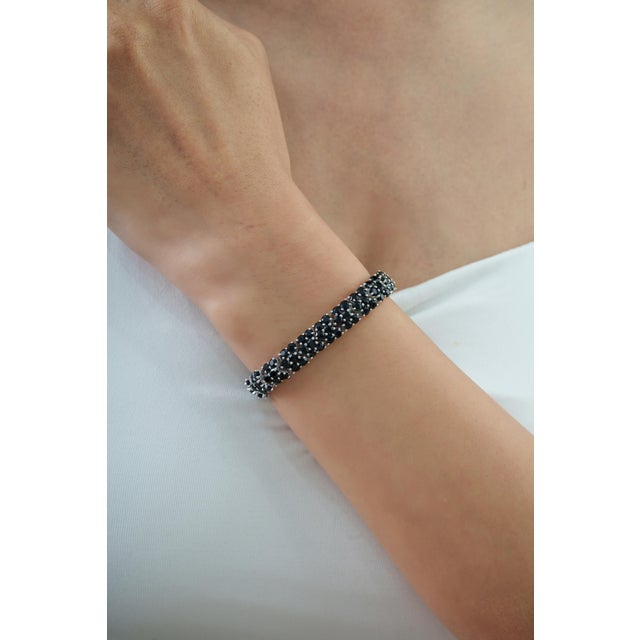 The Wide Three-Row Mosaic 14.37 CTW Black Onyx Tennis Bracelet features 14.37 carats of Black Onyx arranged in three rows...