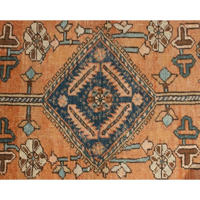 A 19th century Persian Heriz rug with central diamond medallion amidst a field of flowers, surrounded by an intricately...