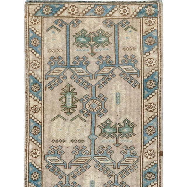 This mid-20th-century Turkish Anatolian runner presents a highly stylized garden design arranged across a warm ivory...