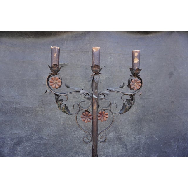 Spanish Revival wrought iron candelabra floor lamp, dating to the 1920s, featuring an ornate three-light design with...
