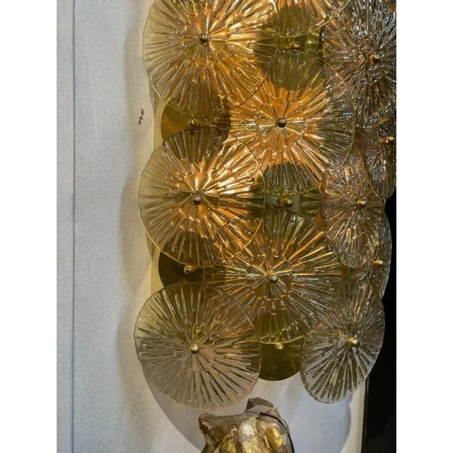 Gorgeous pair of large-scale gold Murano glass and brass disc form sconces. A favorite of designers. Makes an impressive...