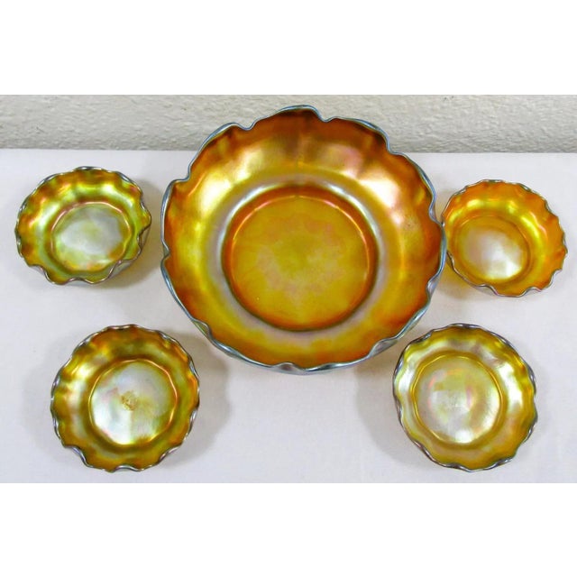 The Louis Comfort Tiffany Iridescent Gold Favrile Ruffled Glass Master Salt and Individual Salts is a 5 Piece set includes...