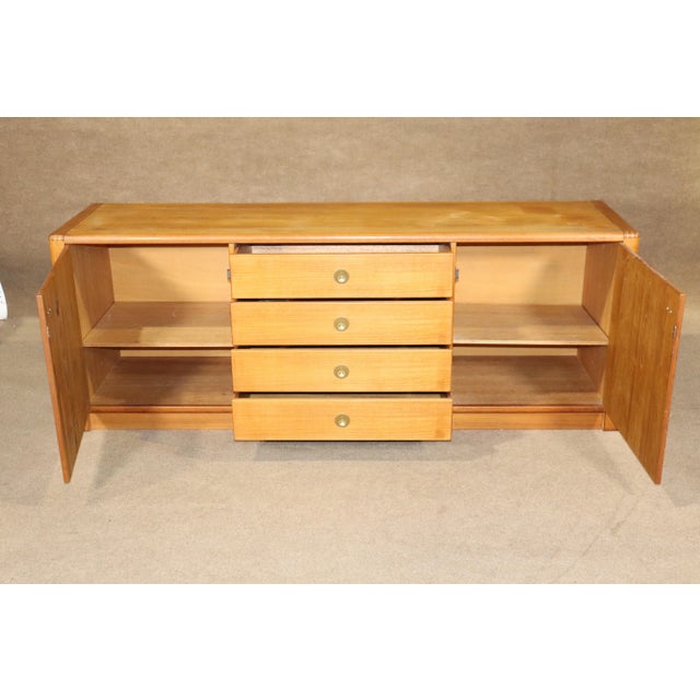 Long Danish designed sideboard with brass hardware. Four middle drawers and side cabinet storage. Beautiful notch joinery...