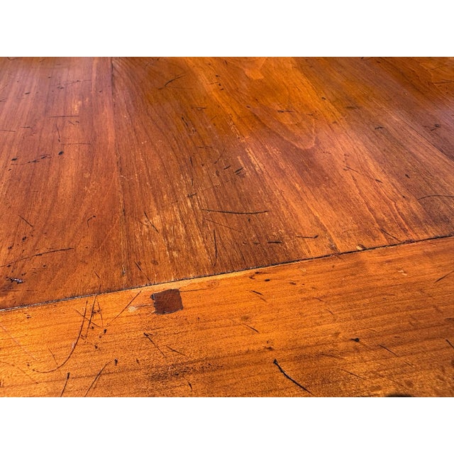 This is a vintage late 20th century French country style dining table. The table features soft curved legs with a...