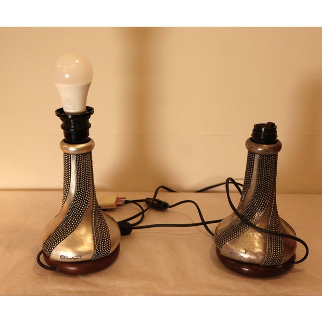 A pair of beautiful silver bases crafted with a helical punched motif. The silver body rests on a walnut disc, is rounded...