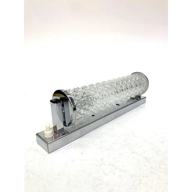 Tubular chiseled glass and chrome plated wall light, 1970s. European Plug (up to 250V).The wiring of this item may be...