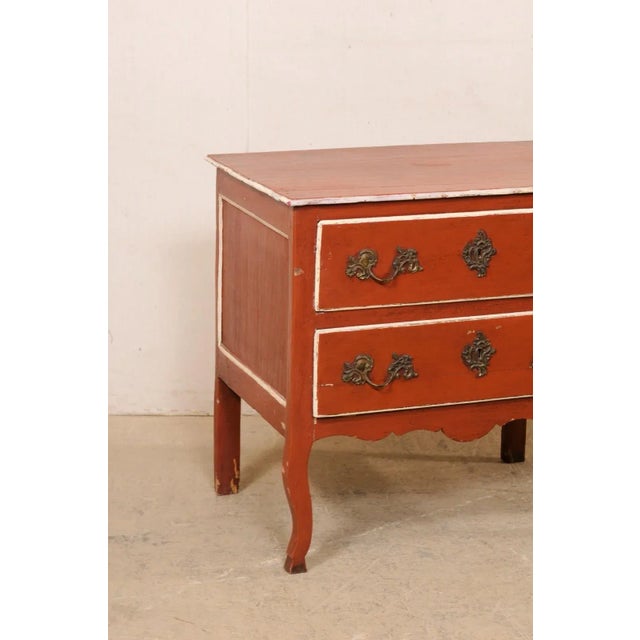 A French raised two-drawer chest, with its original finish, from the early 19th century. This antique commode from France...