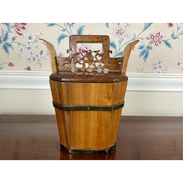 A Qing Dynasty hand-carved and lacquered elm wood teapot caddy with elaborate carvings on the handle and bucket and two...