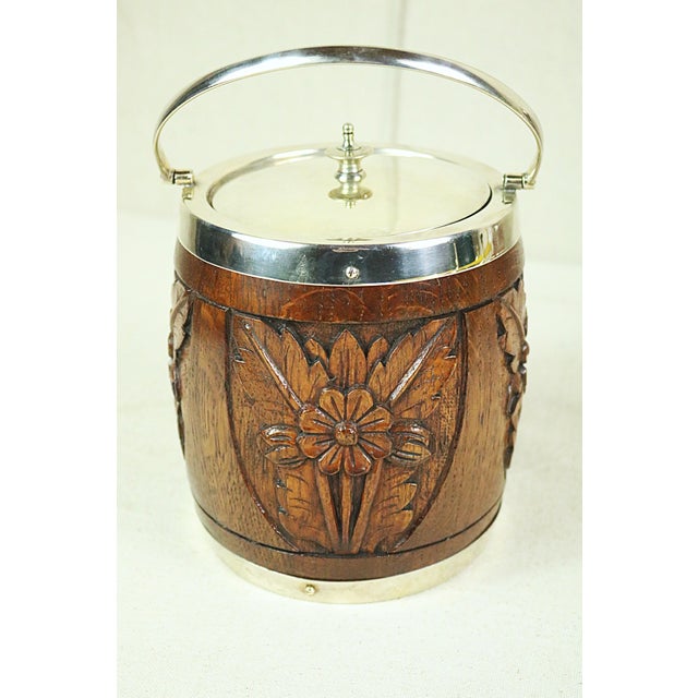 A late 19th century English biscuit barrel (cookie jar) dating from the end of the 19th century and made of carved oak...