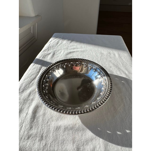 An authentic Reed & Barton sterling silver bowl in the X473 pattern, distinguished by an elegantly detailed floral and...