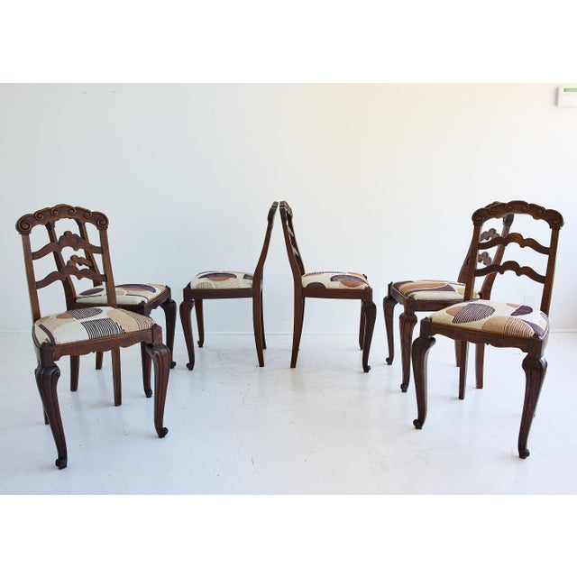 An incredible set of six French Provincial dining chairs in dark-stained oak. Dating to the early 20th century, the set...