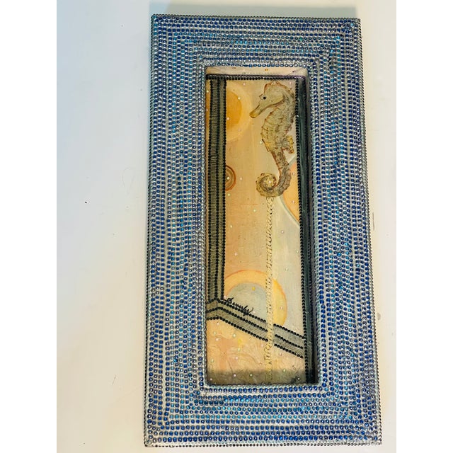 Unique American art by Beverly Robert’s Seahorse with blue beaded collage frame.