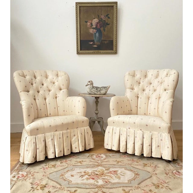 Newly upholstered in a textured weave sateen fabric, this pair of elegant Edwardian button back chairs, have a pleated...