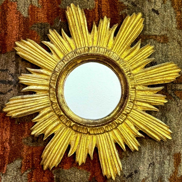 This is a lovely Hollywood Regency Italian carved giltwood sunburst mirror. It has the Florentine label on the back of the...