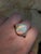 This captivating ring features a luminous 7.11ct oval Ethiopian opal (16.8x13.2mm), celebrated for its vivid play of...