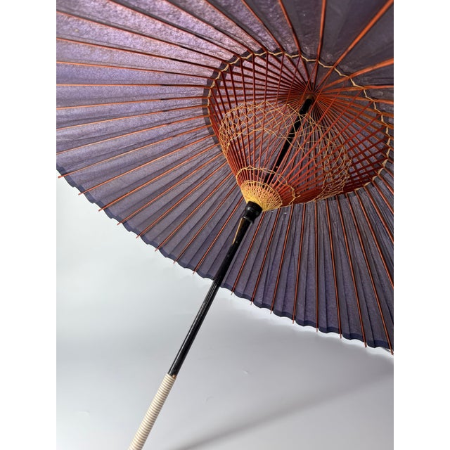 This is a vintage Japanese “snake-eye” style wagasa umbrella, traditionally crafted with a bamboo frame and lacquered...