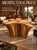 A sculptural table base crafted from an organic cypress tree trunk, featuring wide splayed roots and a flat top surface...