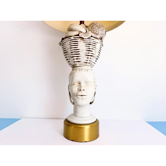 Stunning sculptural modern lamp of a woman holding a wicker basket filled with fruit atop her head in creamy white glazed...