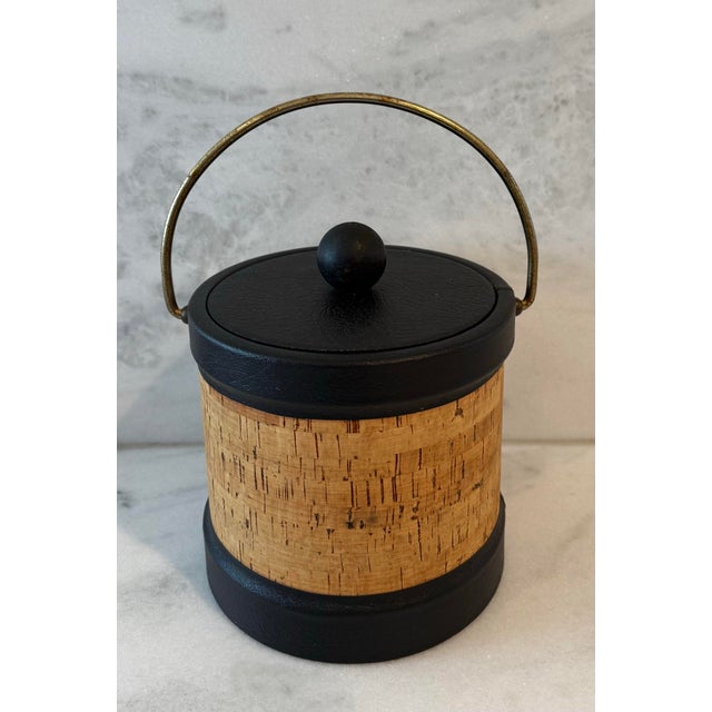 Vintage mid century modern ice bucket with cork exterior, black faux leather trim and a brass handle, made by Kraftware...