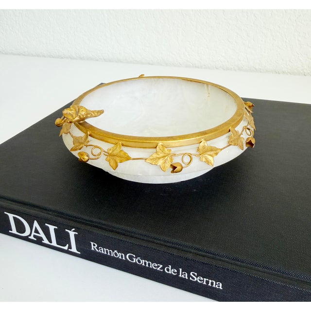 An ornate mid-20th-century vintage Italian alabaster ashtray or catchall bowl with a decorative gilt-brass metal ivy leaf...