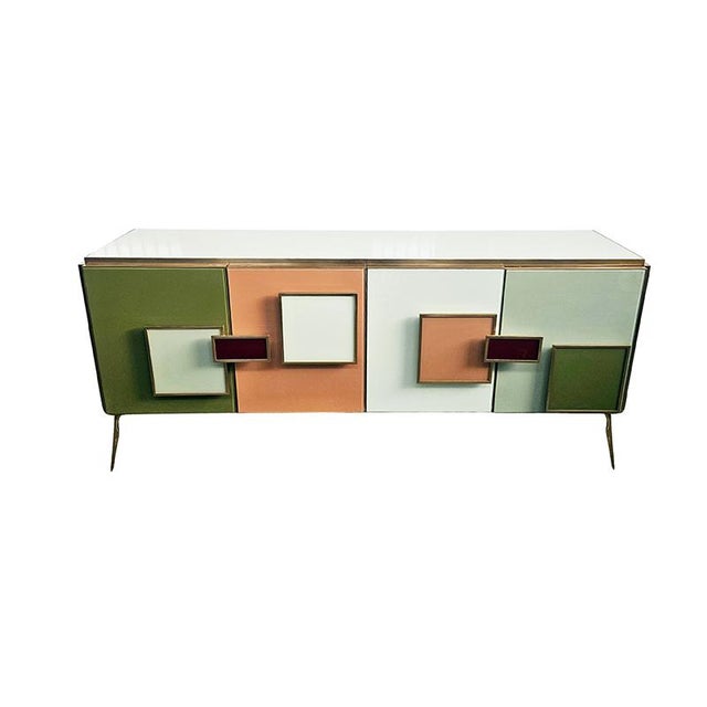 Four-door sideboard with internal shelf, entirely handmade, with a wooden frame covered in colored glass. Gilded brass...