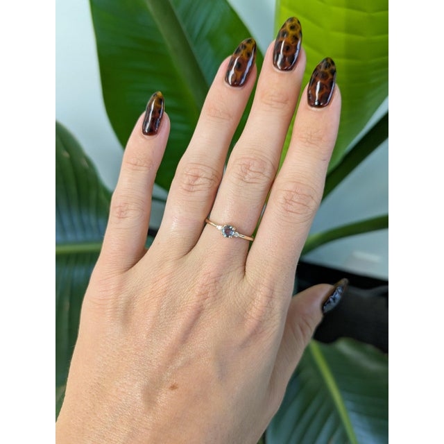 A natural colour-change alexandrite glows at the centre of this solid 14K yellow gold ring, flanked by two earth-mined...