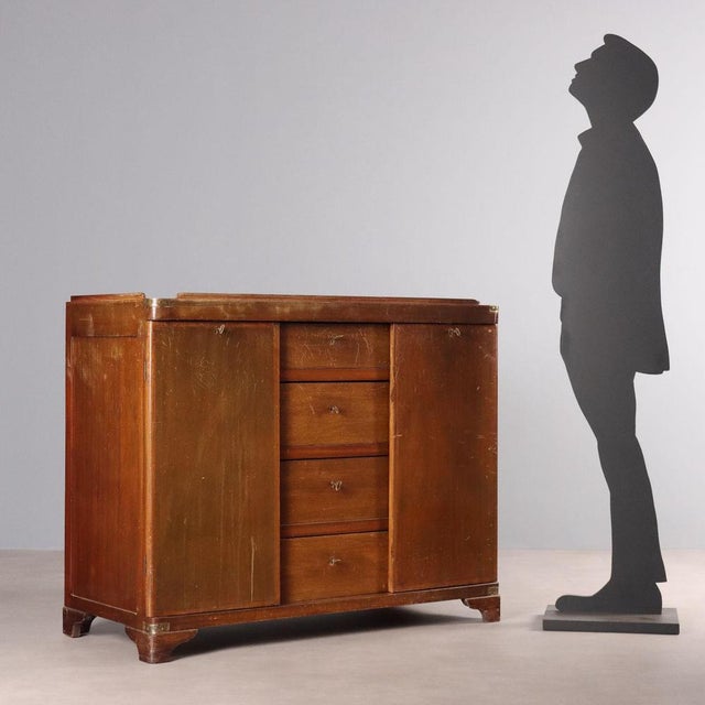 Mahogany chest of drawers, front with four drawers enclosed by a pair of doors, bracket feet, brass details. Italy,...