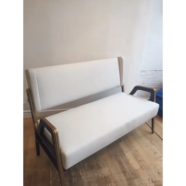 Newly reupholstered in ivory linen this stylish settee has black lacquered arms and legs with gold detail Unusual and high...
