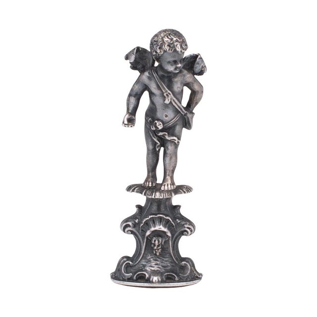 This is a beautifully detailed example of a late 19th or early 20th century silver wax seal or desk stamp, the handle of...