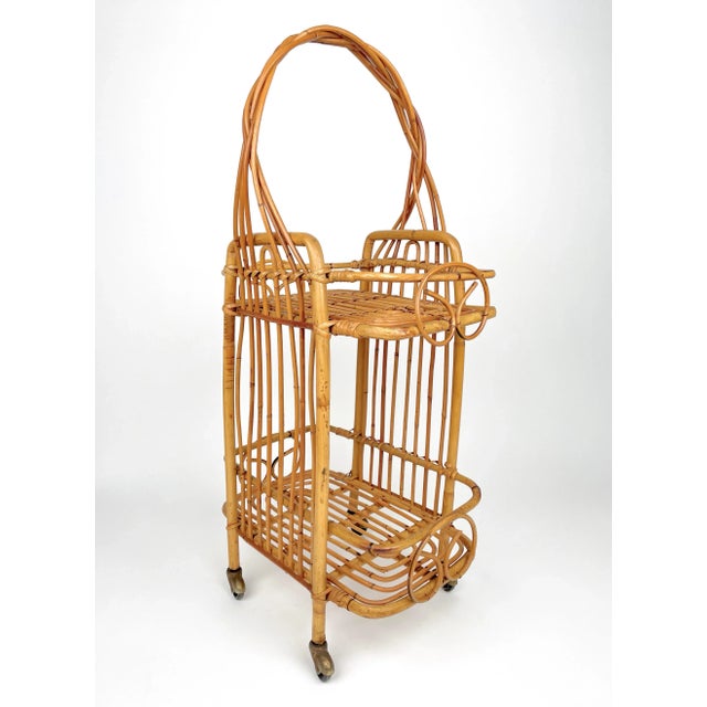 Small bamboo bar cart, two levels, with originals wheels and an elegant braided handle. Made in Franche in the 1960s.