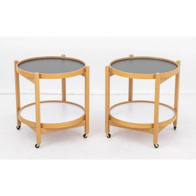 Pair of Hans Bolling Style Two-Tier Rolling Side Tables, each with wood frame, two removable circular tray tops, and on...